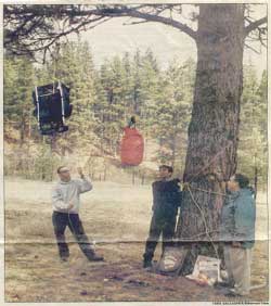 Victor High School junior BenDrewien, left, takes a turn hoisting a back pack to bear-proof a camp, as part of exercises prepared by Chuck Bartlebaugh of The Center for Wildlife Information, foreground.  Drewien and Jorge Cano, right, were among several high school students who helped train younger students to be safe and responsible around wildlife.